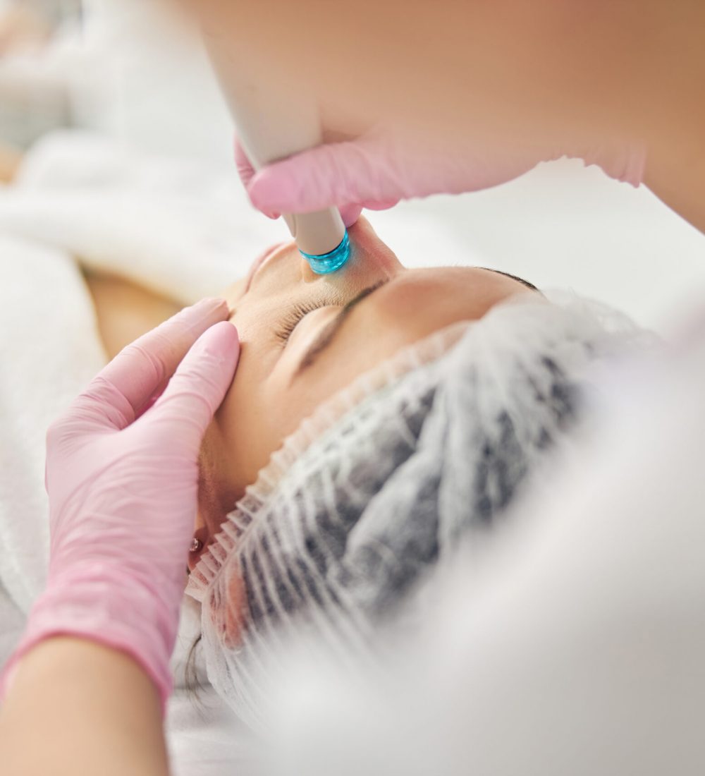 Eine Fachkosmetikerin führt bei einer Patientin eine HydraFacial-Behandlung mit einem modernen Gerät durch. Das Bild zeigt die sanfte, medizinisch-ästhetische Hautreinigung bei Festhetic Medical Düsseldorf für ein sichtbar frisches und glattes Hautbild.